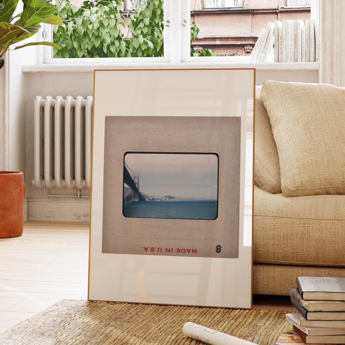 a framed photograph of a bridge, placed on a rug in a living room setting.