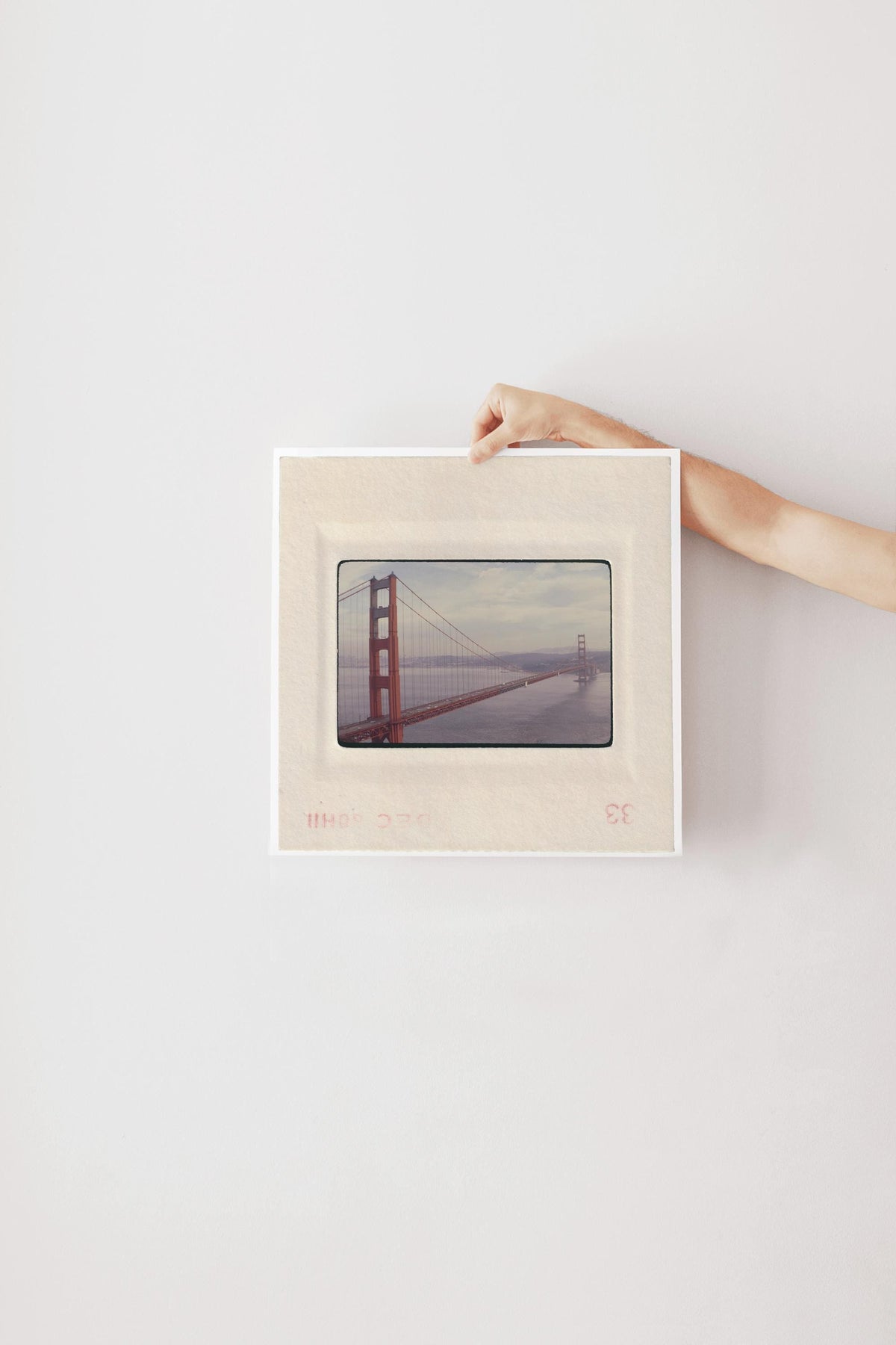 Vintage December 1958 color slide photograph of the Golden Gate Bridge's full span viewed from beside the north tower, sweeping dramatically across San Francisco Bay with cars on the deck and Marin hills in the background, printed as a fine art giclée print.