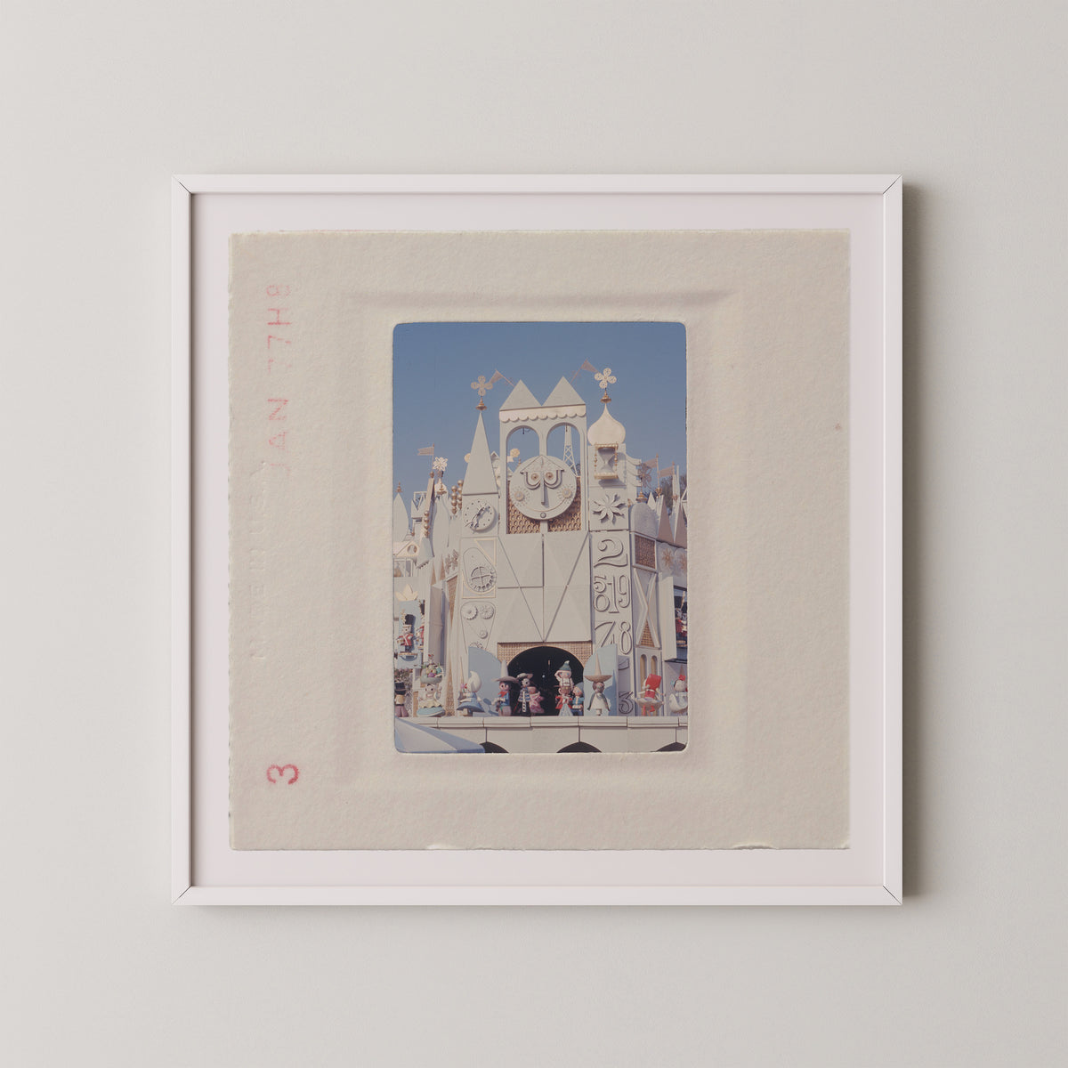 The image is a framed photograph of a miniature castle or palace, with various architectural details and decorations visible.