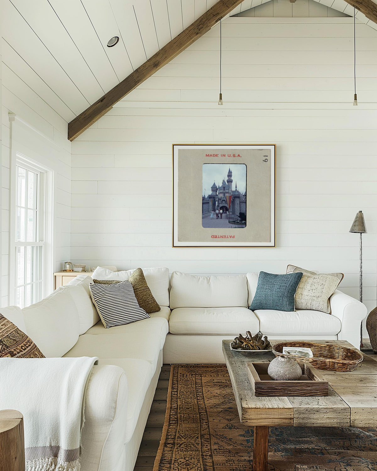 a cozy living room with a white sofa, a wooden coffee table, and a framed picture of a cityscape hanging on the wall.