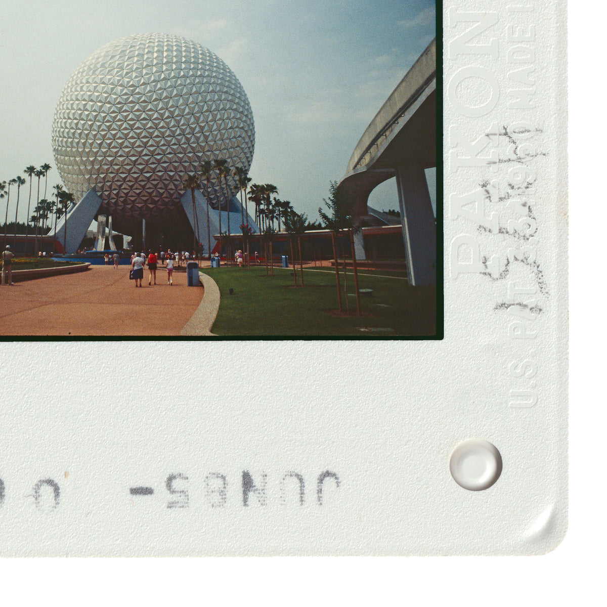 a large, spherical structure with a distinctive geometric design, surrounded by palm trees and a paved walkway.