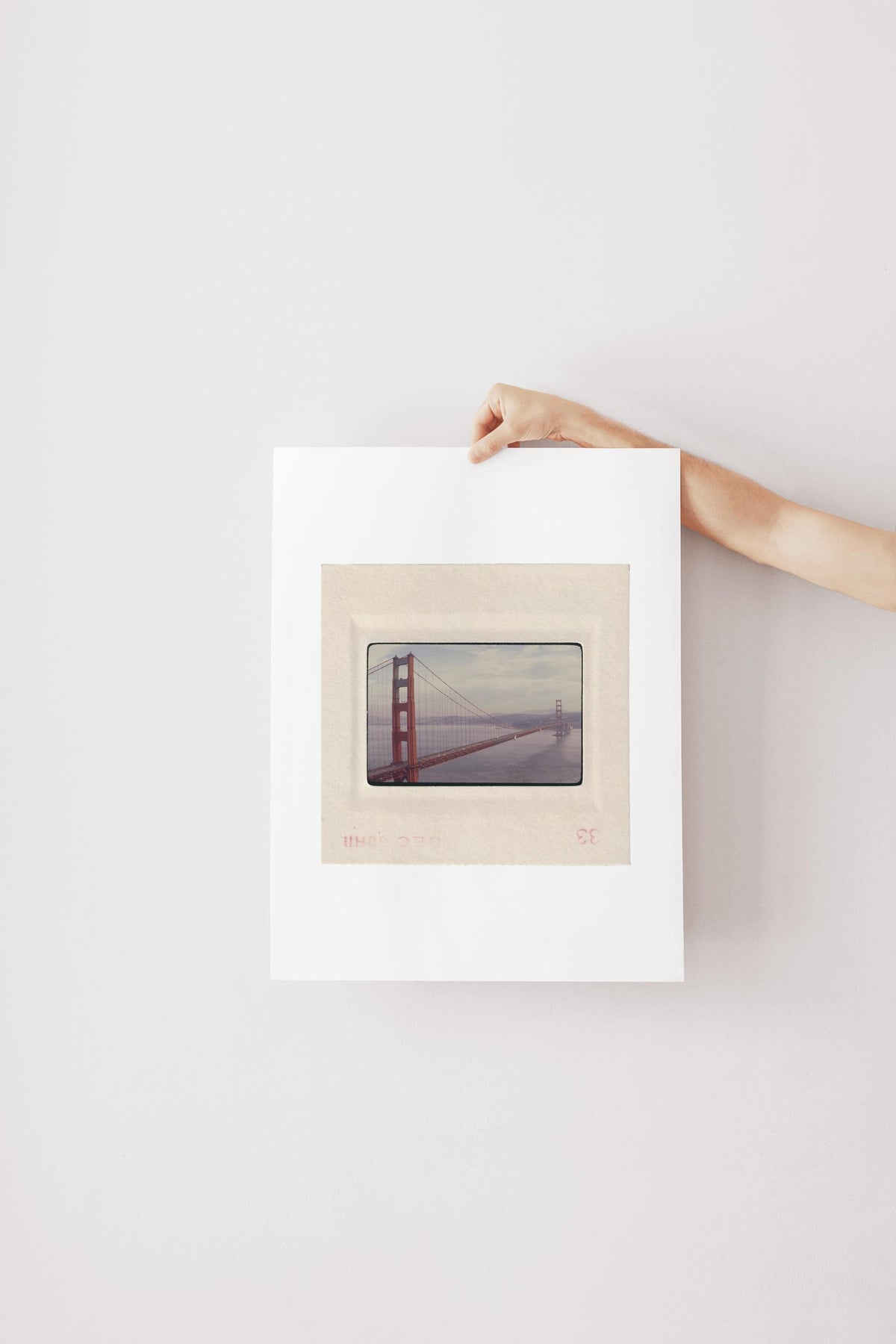 Vintage December 1958 color slide photograph of the Golden Gate Bridge's full span viewed from beside the north tower, sweeping dramatically across San Francisco Bay with cars on the deck and Marin hills in the background, printed as a fine art giclée print.