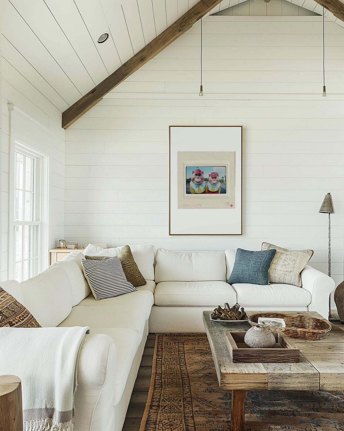 a cozy living room with a white sofa, a wooden coffee table, and a framed artwork on the wall.