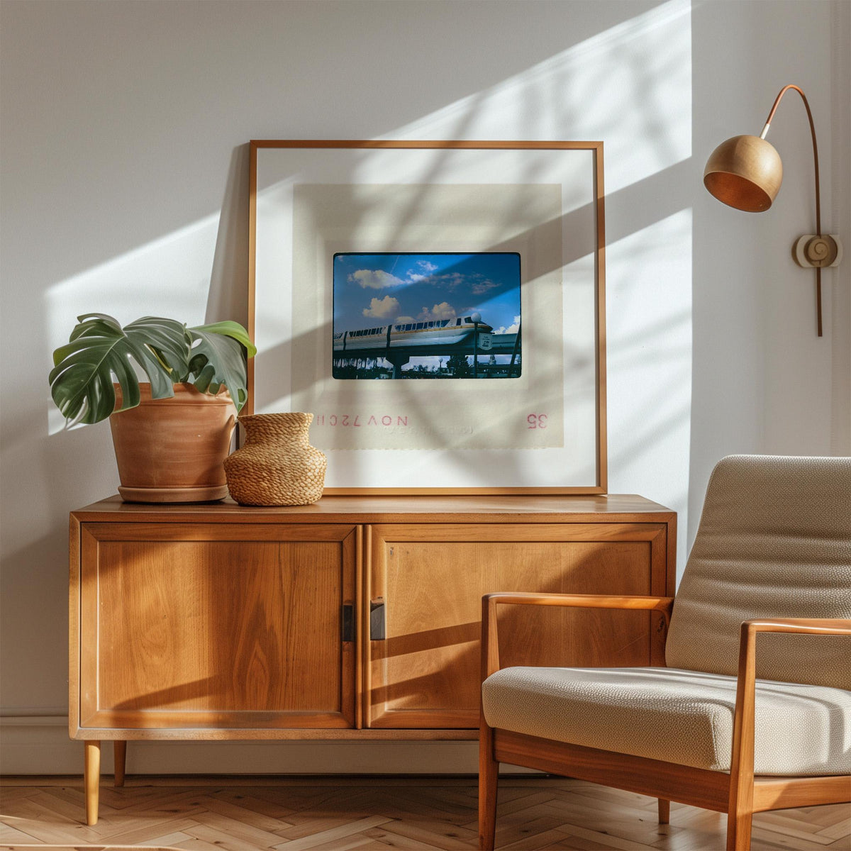 a cozy living room with a wooden cabinet, a framed picture of a tropical beach, a potted plant, and a beige armchair.