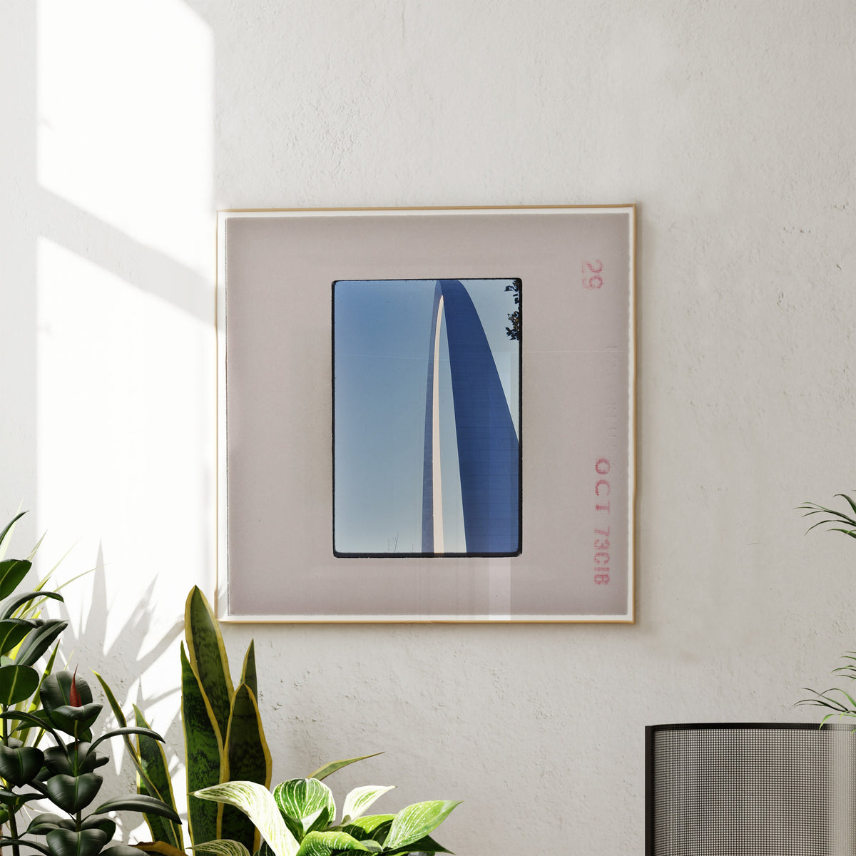 a framed photograph of a blue and white sailboat on a sunny day, hanging on a white wall.