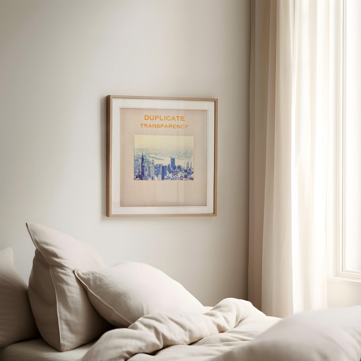 a bedroom with a bed, a framed poster of a city skyline, and a window with sheer curtains.