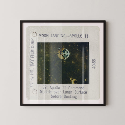 The image is a framed photograph of a space shuttle, specifically Apollo 11, during its moon landing.