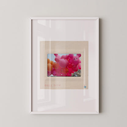 The image is a framed photograph of a bunch of colorful balloons floating in the air.