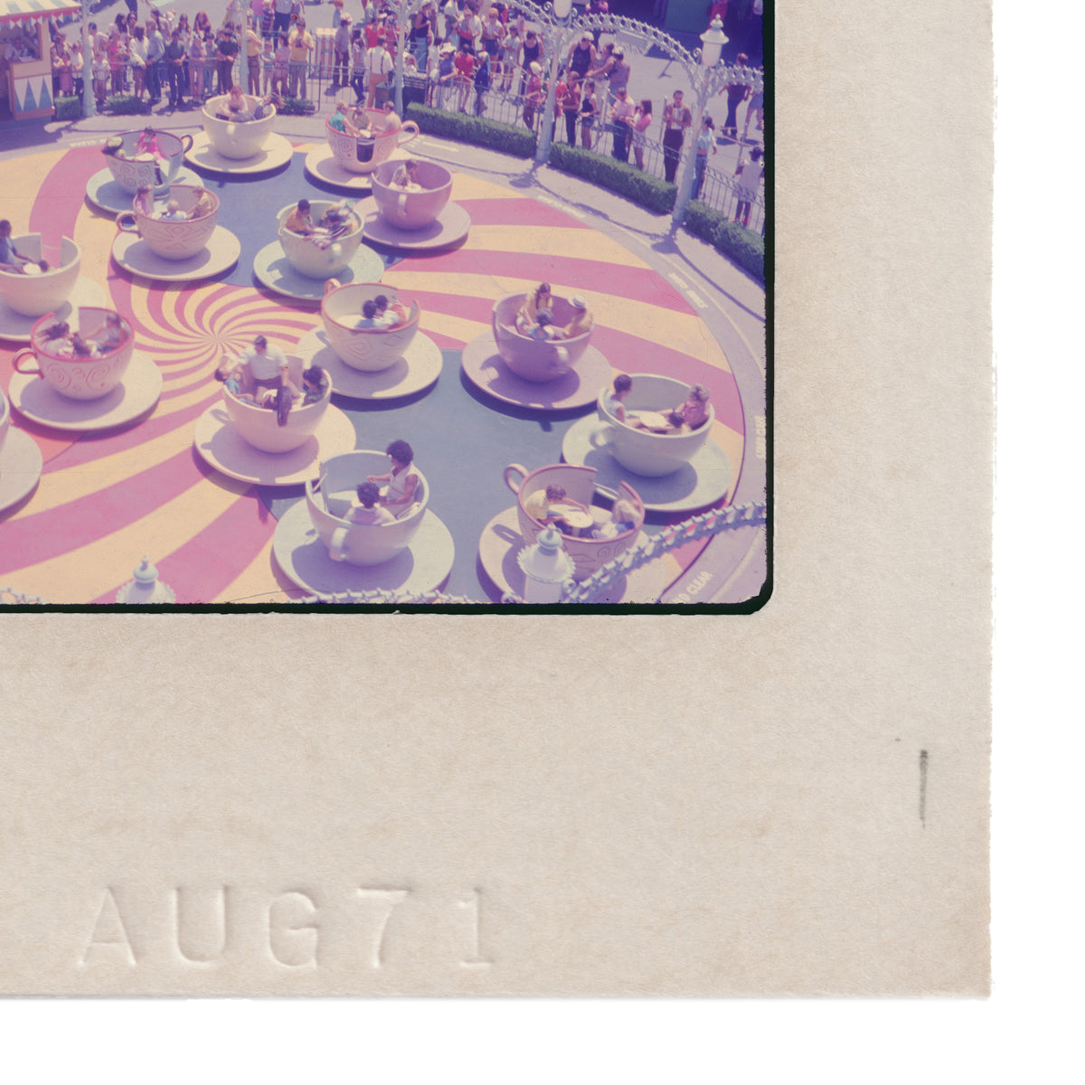A group of people enjoying a ride on a merry-go-round, with colorful cups and saucers on the platform.