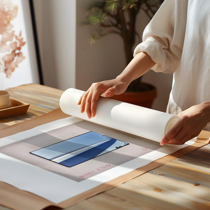 A person is rolling up a piece of paper with a printed image on it, which appears to be a framed print or artwork.