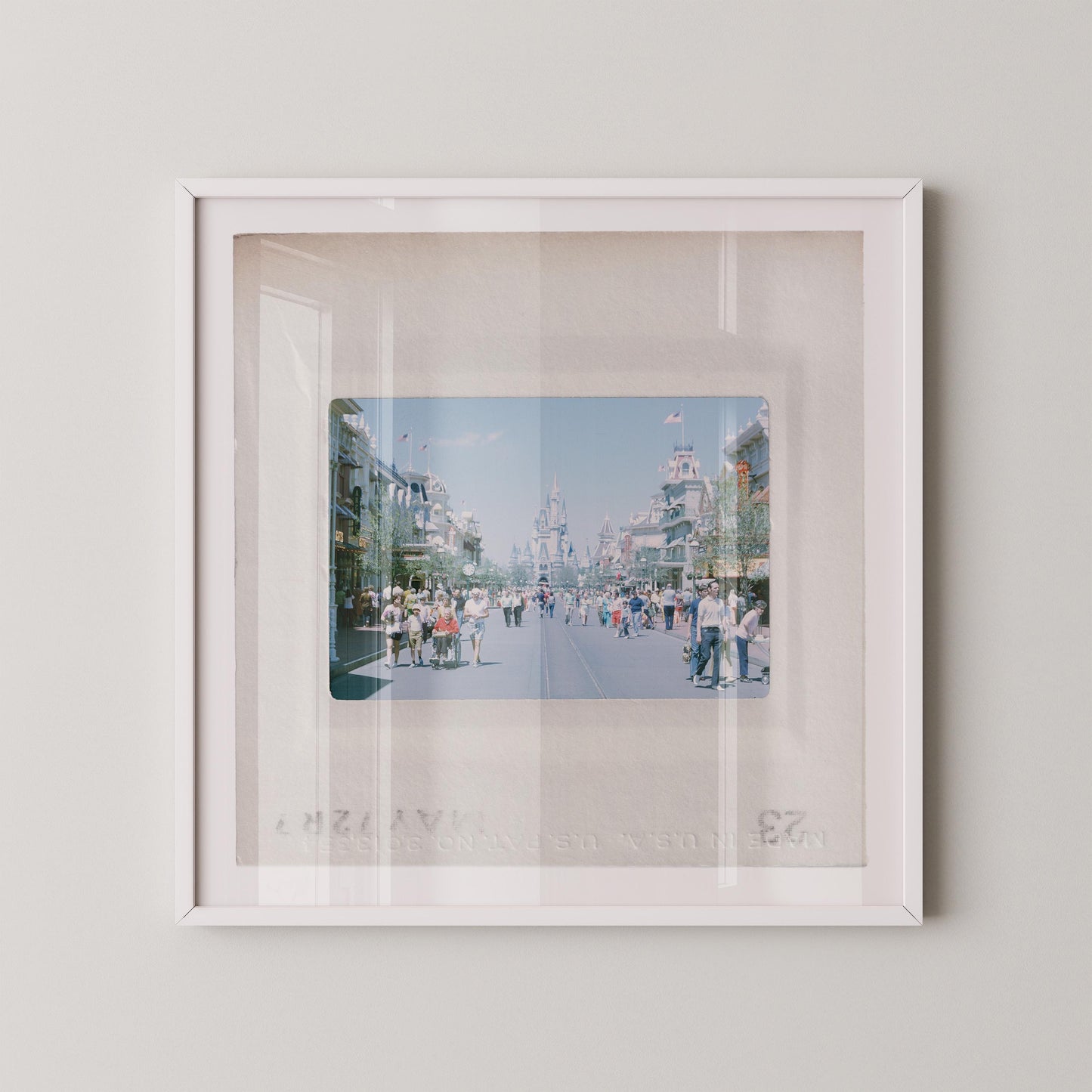 A framed photograph of a busy street scene with people walking and buildings in the background.