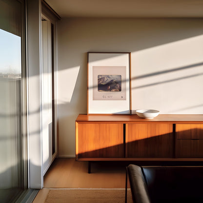a modern living room with a wooden cabinet, a framed artwork on the wall, and a window with white blinds.