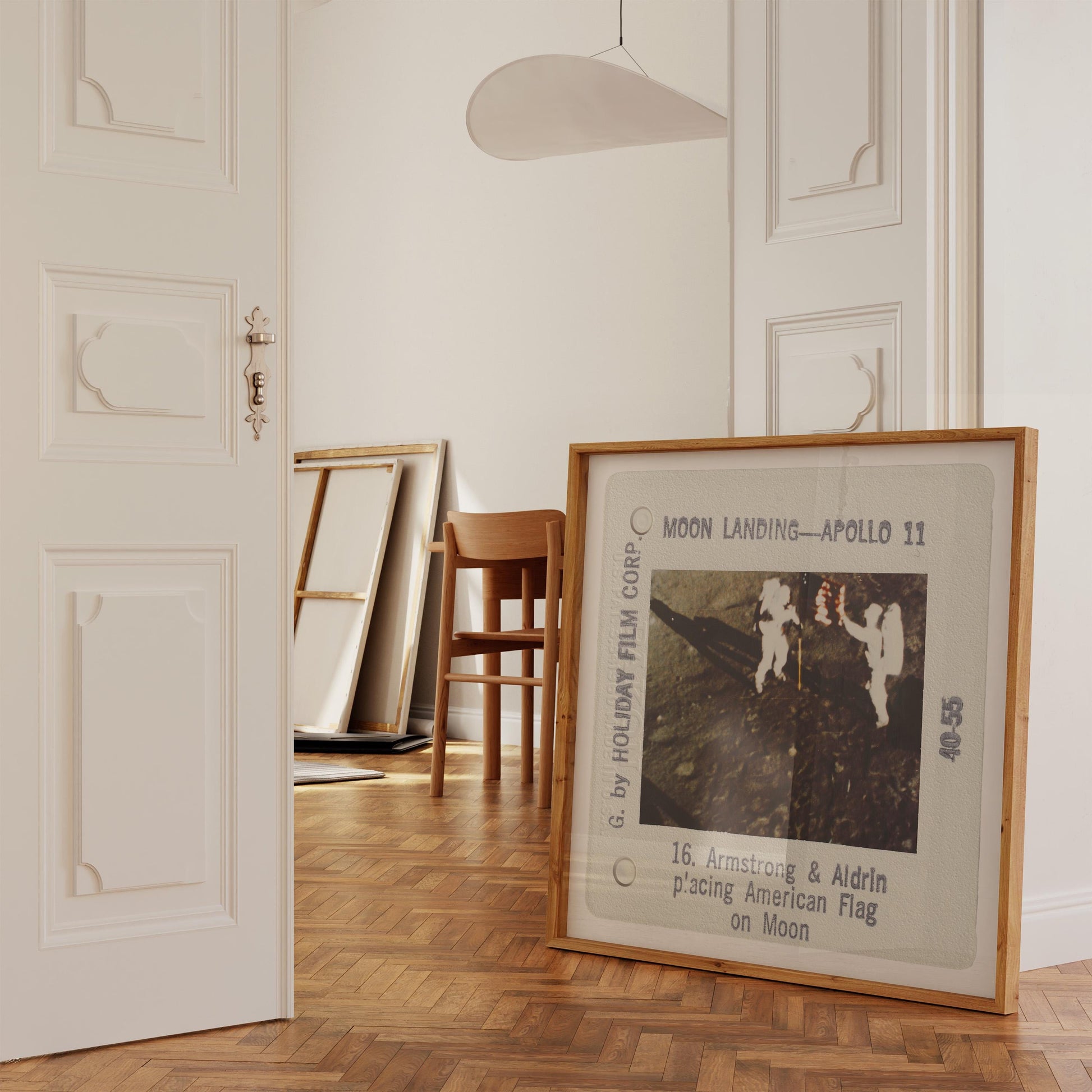 a framed photograph of the Apollo 11 moon landing, with the text "Moon Landing - Apollo 11" and "16. Armstrong & Aldrin placing American Flag on Moon" visible.