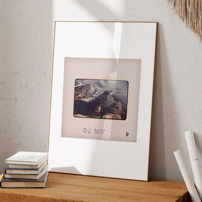 a framed photograph of a mountain landscape, with a small text overlay that reads "JUN".