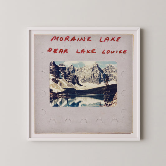 The image is a framed photograph of a scenic mountain landscape, with a lake in the background. The text above the photograph reads "MORAIN LAKE" and "EAR LAKE LOUISE".