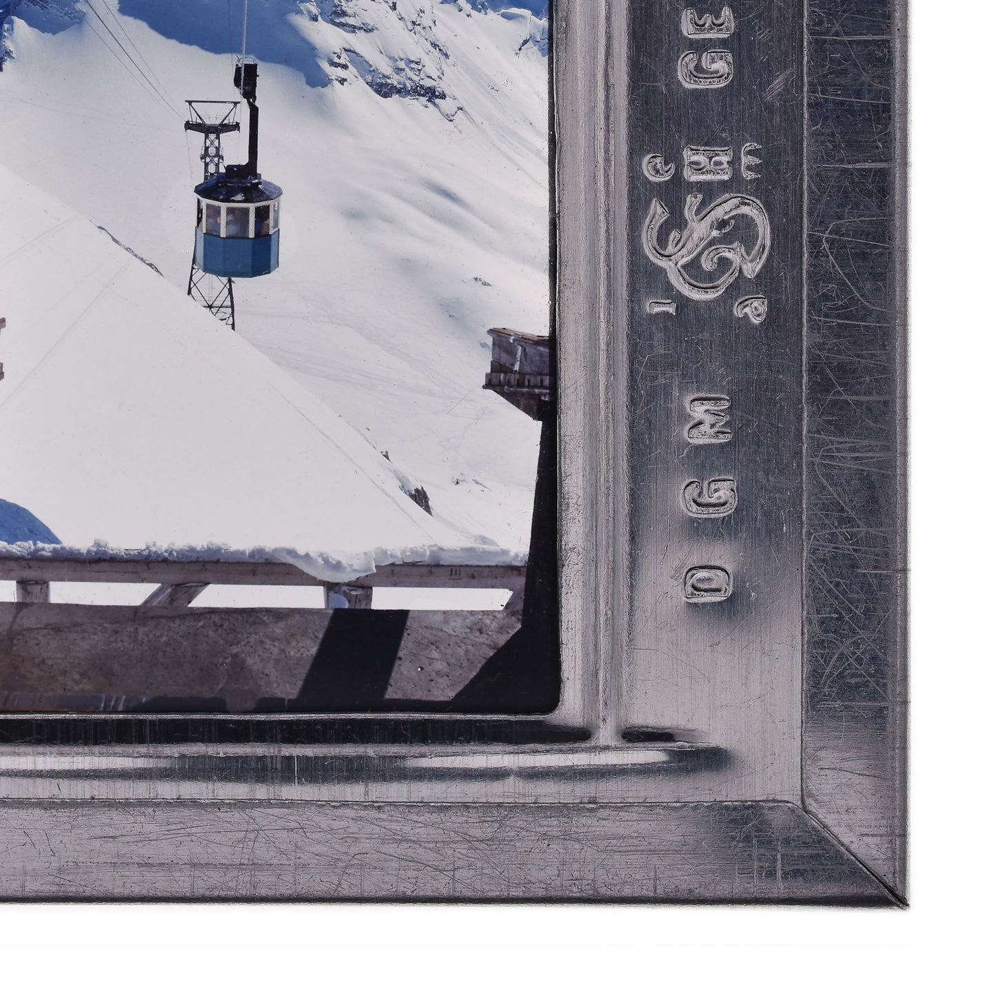 A ski lift is suspended in the air, with a snowy mountain landscape visible below.
