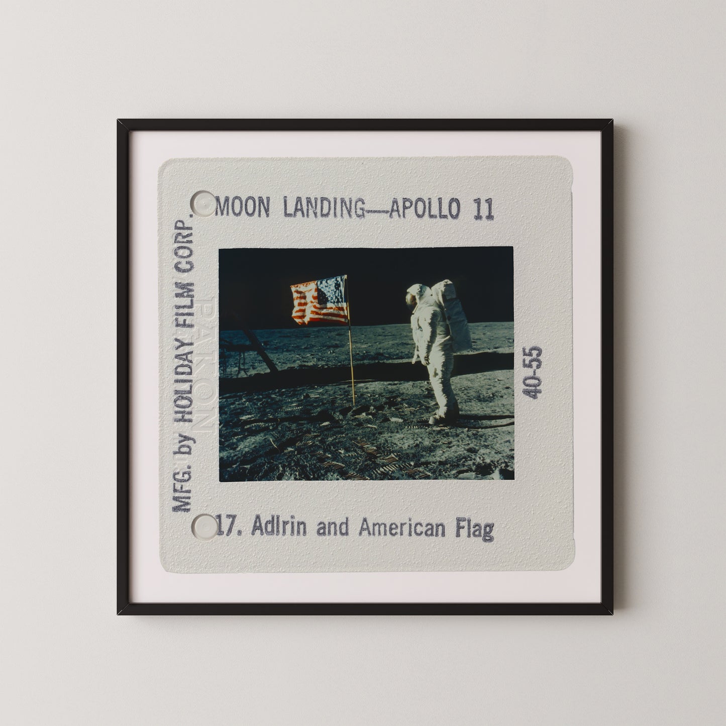 a framed photograph of the Apollo 11 moon landing, with the astronaut standing on the lunar surface holding an American flag.