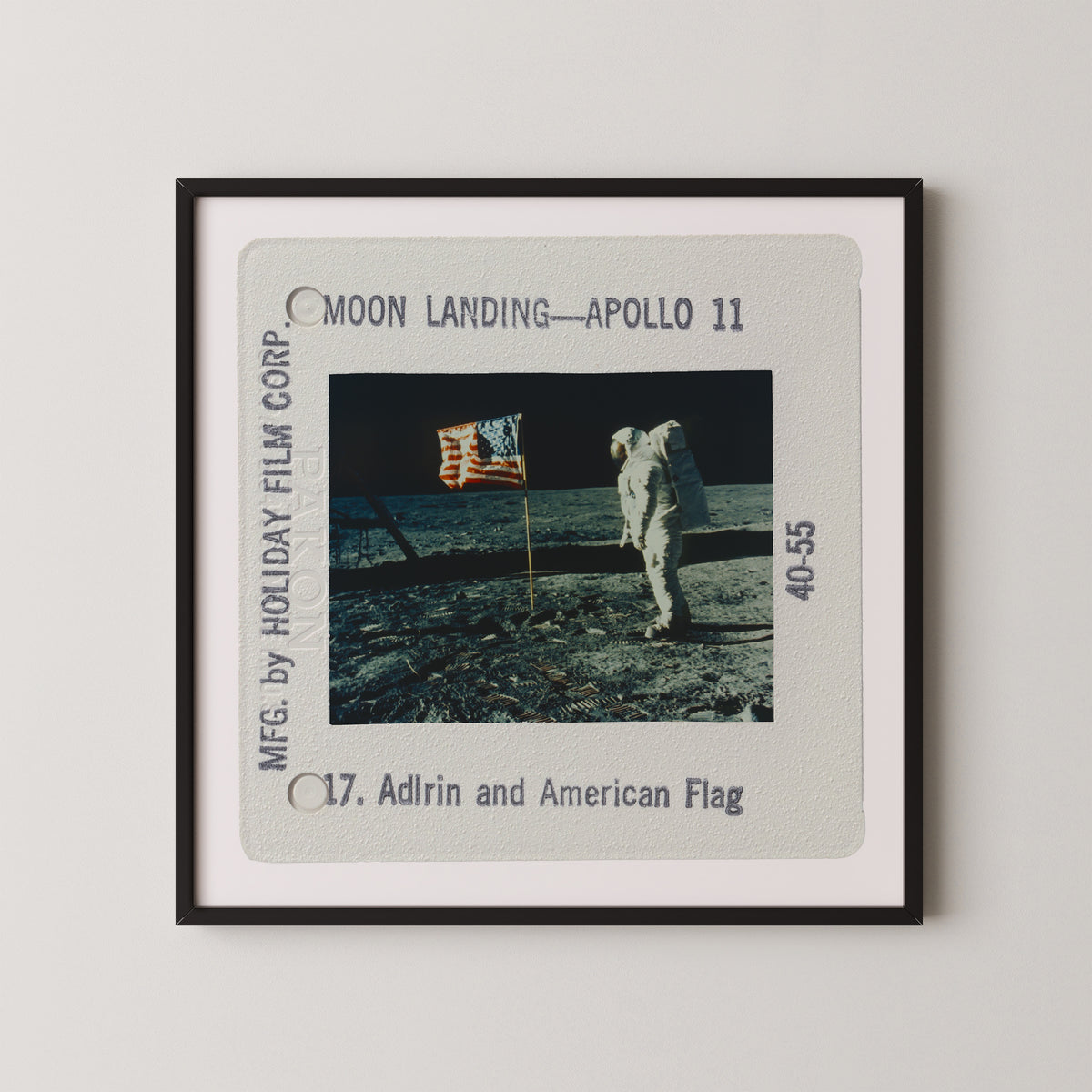a framed photograph of the Apollo 11 moon landing, with the astronaut standing on the lunar surface holding an American flag.