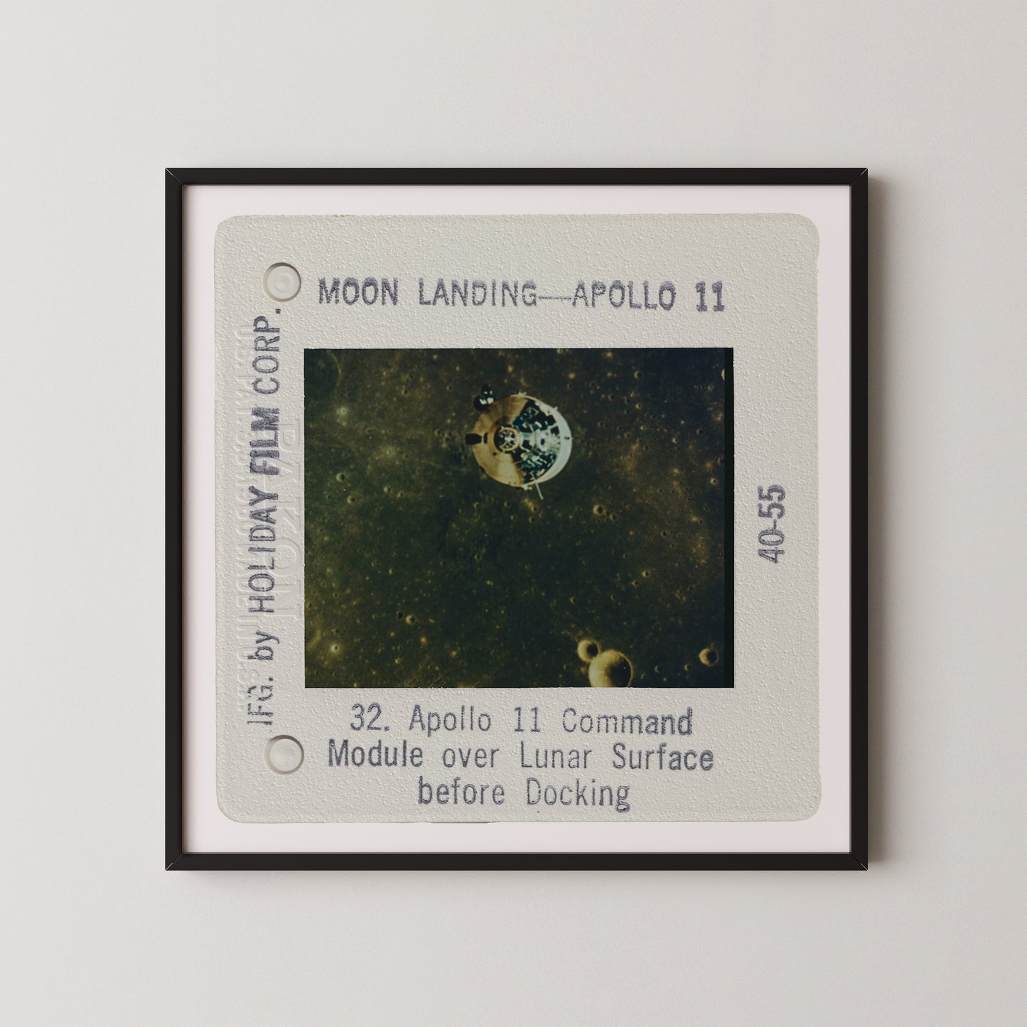 The image is a framed photograph of the Apollo 11 moon landing, showing the lunar module over the lunar surface before docking.