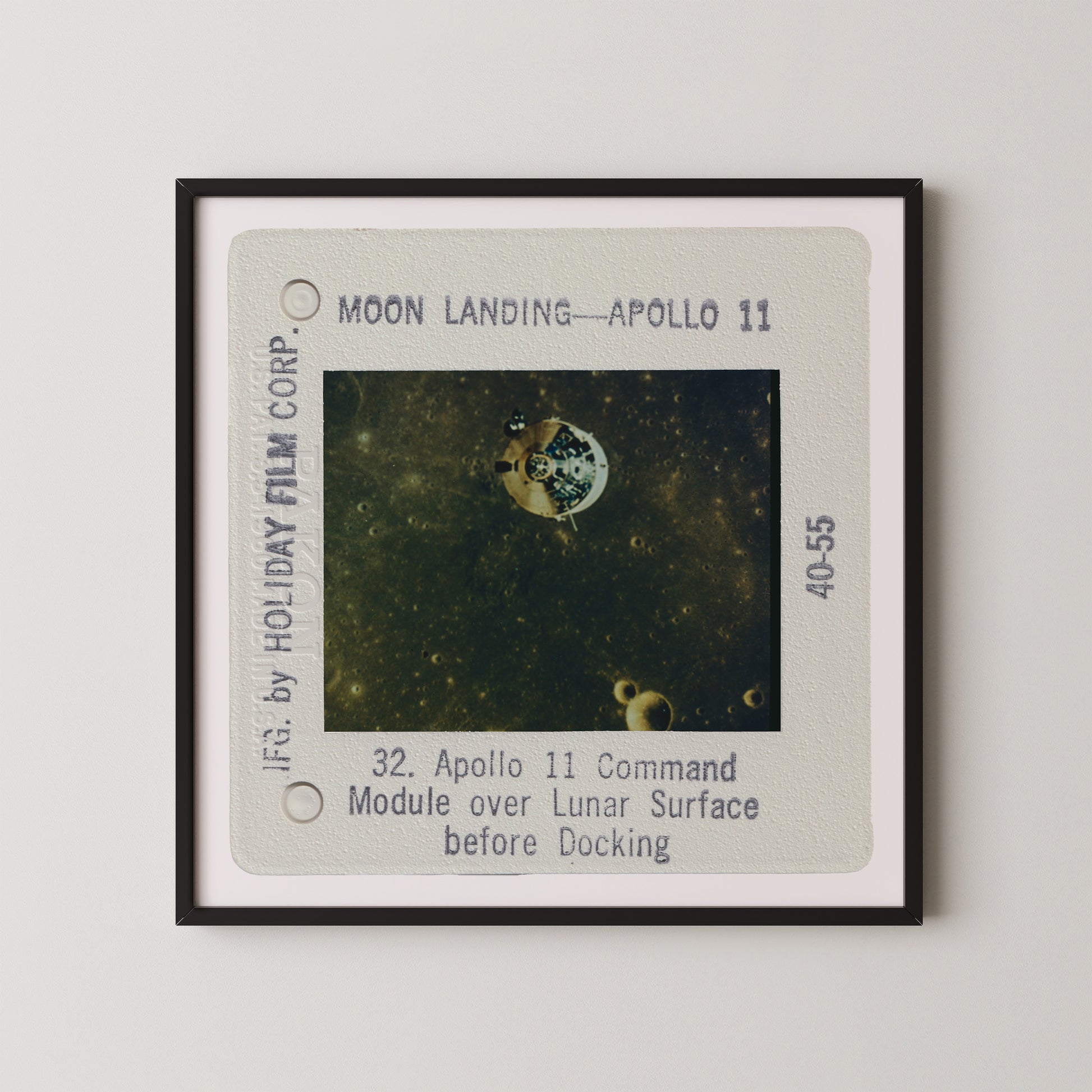 The image is a framed photograph of the Apollo 11 moon landing, showing the lunar module over the lunar surface before docking.
