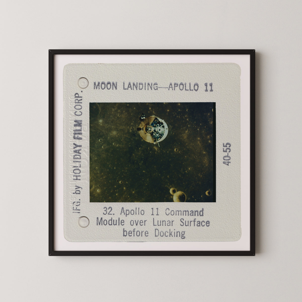 The image is a framed photograph of the Apollo 11 moon landing, showing the lunar module over the lunar surface before docking.