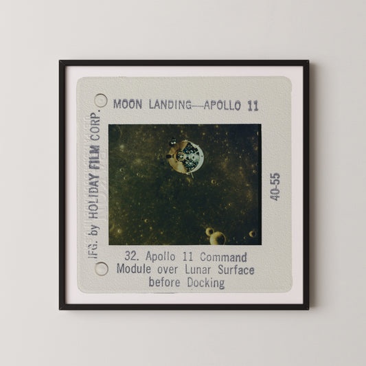 The image is a framed photograph of the Apollo 11 moon landing, showing the lunar module over the lunar surface before docking.