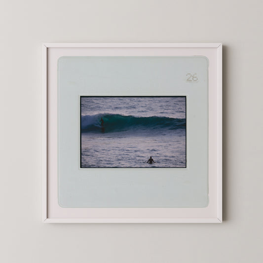 A framed photograph of a surfer riding a wave in the ocean.