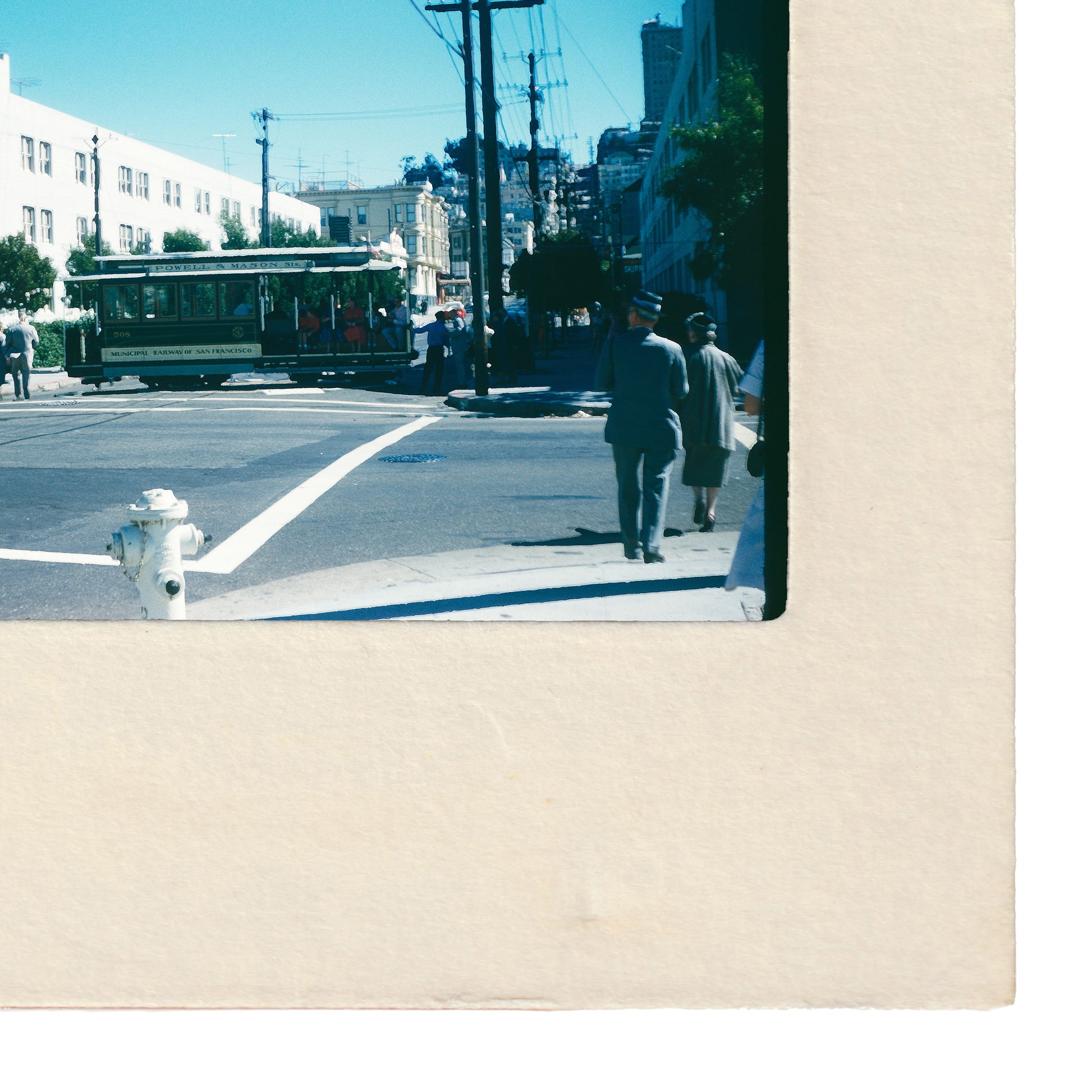 a street scene with a trolley car, a fire hydrant, and people walking on the sidewalk.