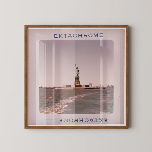 a framed photograph of the Statue of Liberty in New York Harbor, with the text "Ektachrome" and "Ektachrome" visible.