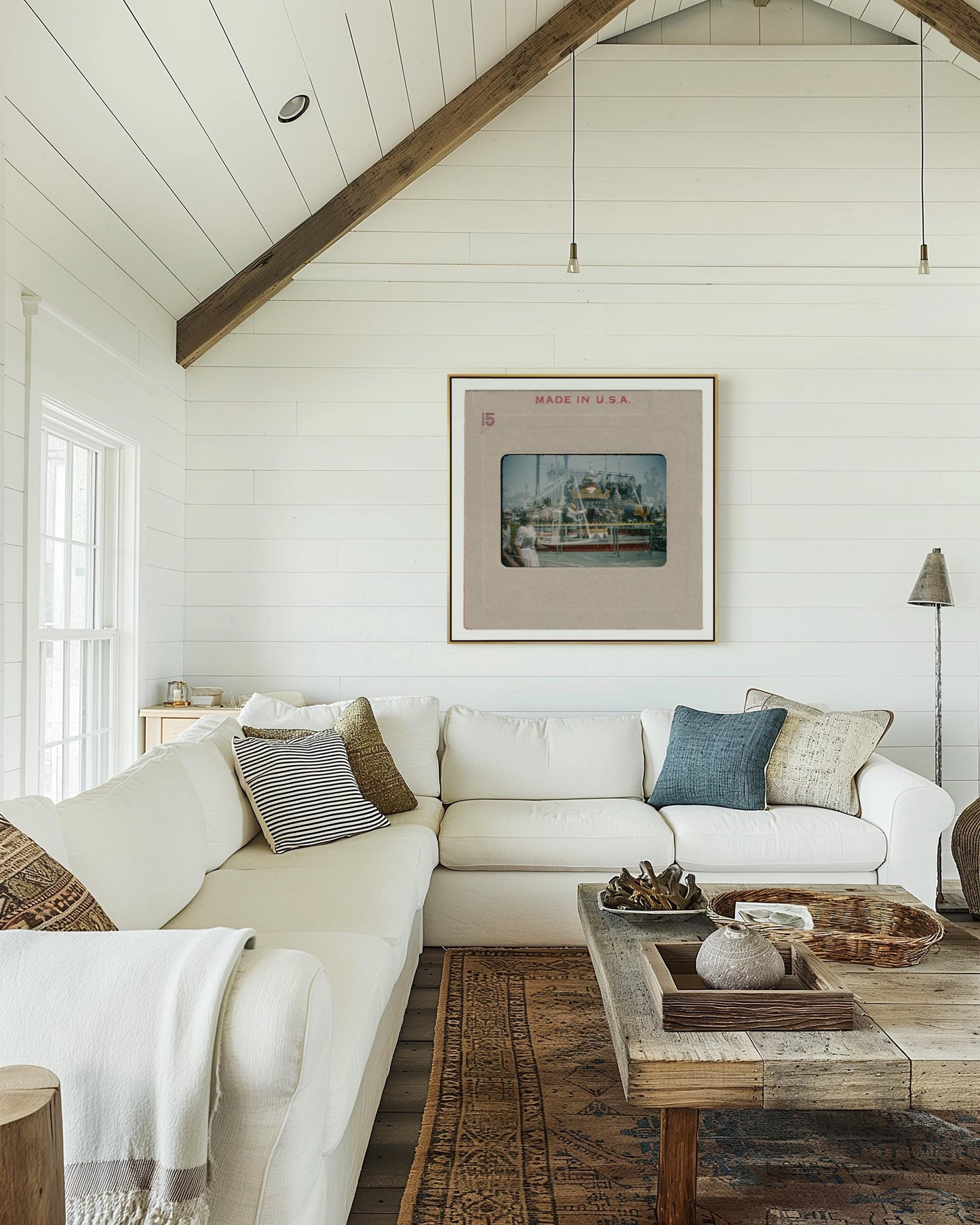 a cozy living room with a white sofa, a wooden coffee table, and a framed artwork hanging on the wall.