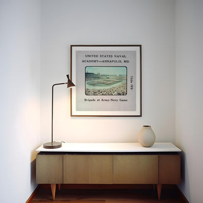 a framed vintage photograph of a baseball stadium, with a lamp and a vase on a wooden cabinet below it.