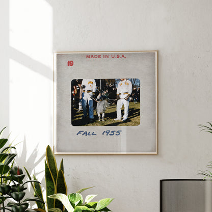 The image is a framed photograph of a group of people, likely from the year 1955, hanging on a wall.