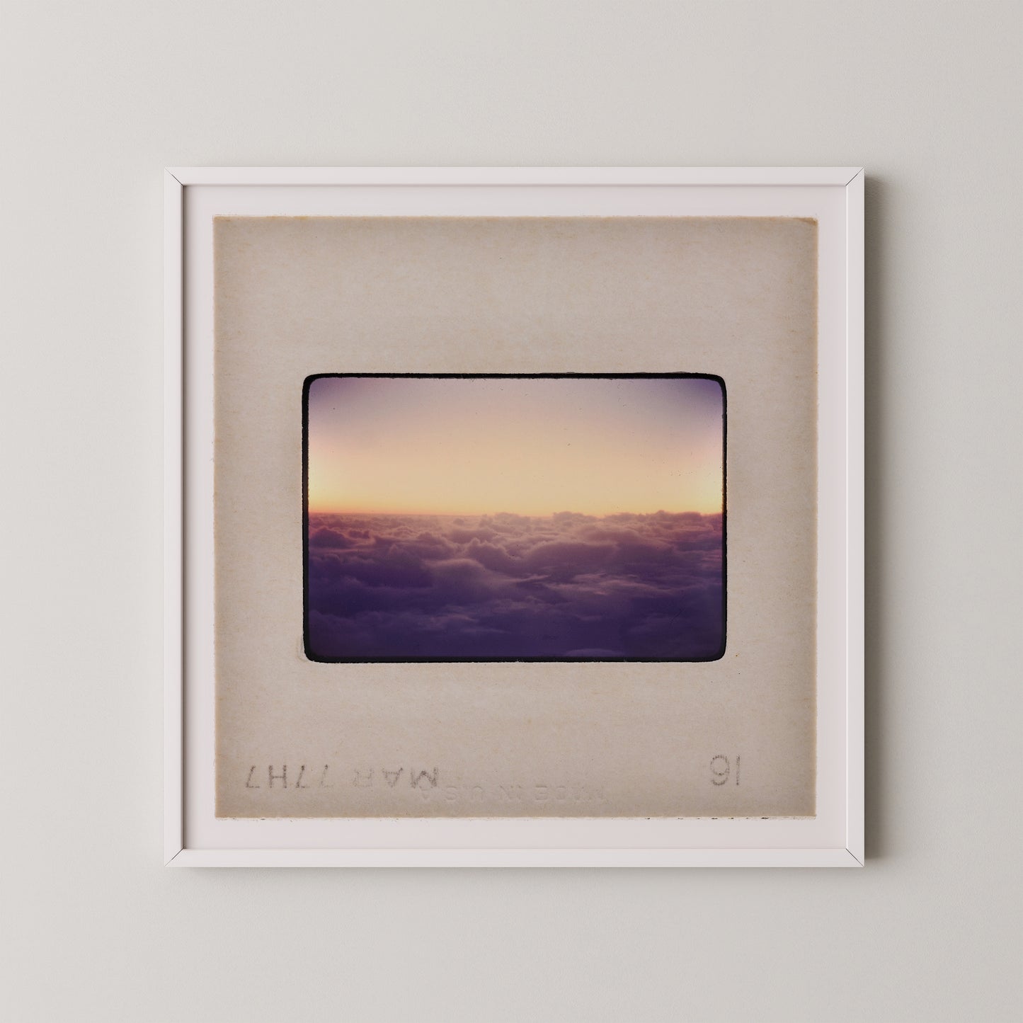 The image is a framed photograph of a sunset over a cloudy sky.