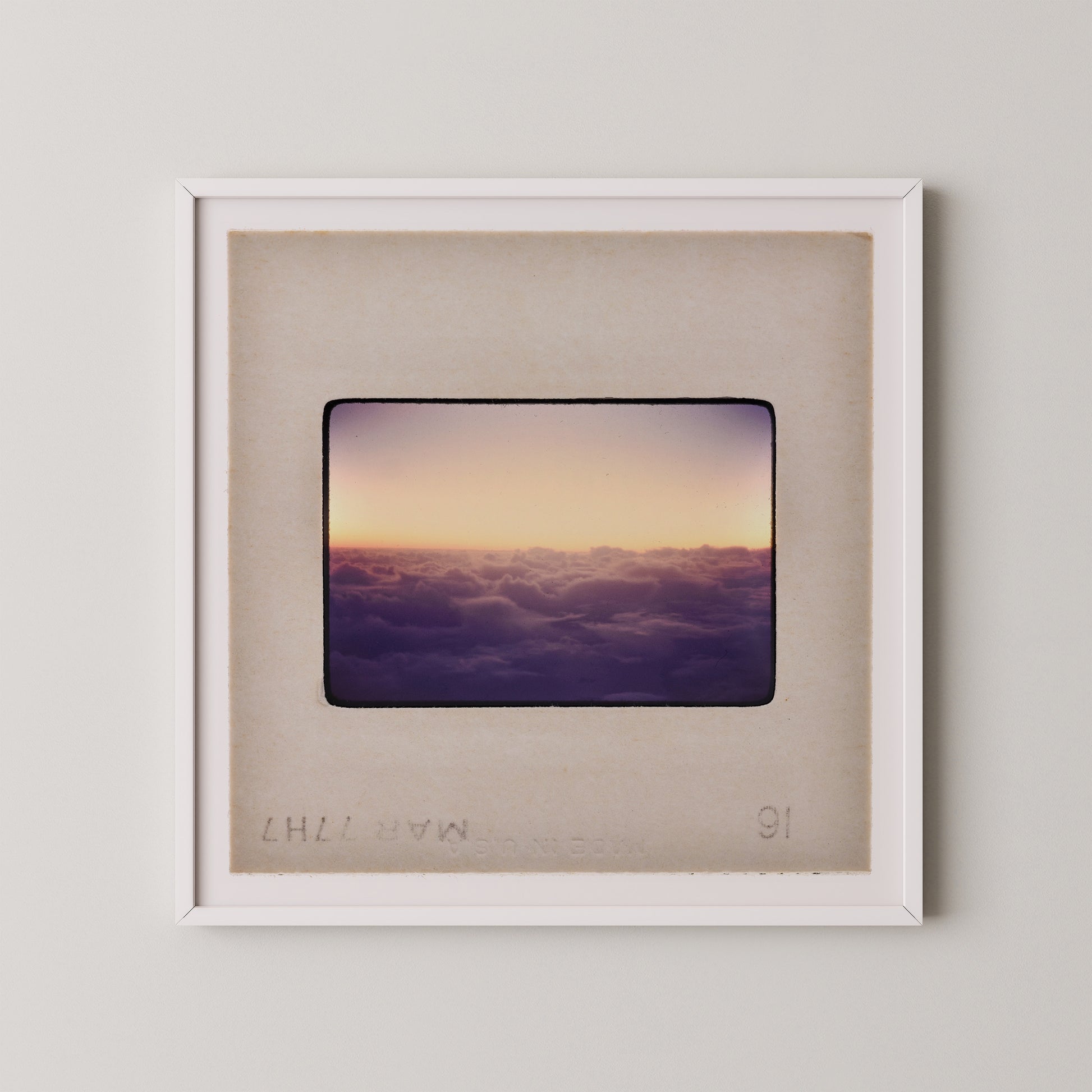 The image is a framed photograph of a sunset over a cloudy sky.