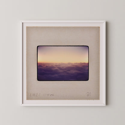 The image is a framed photograph of a sunset over a cloudy sky.