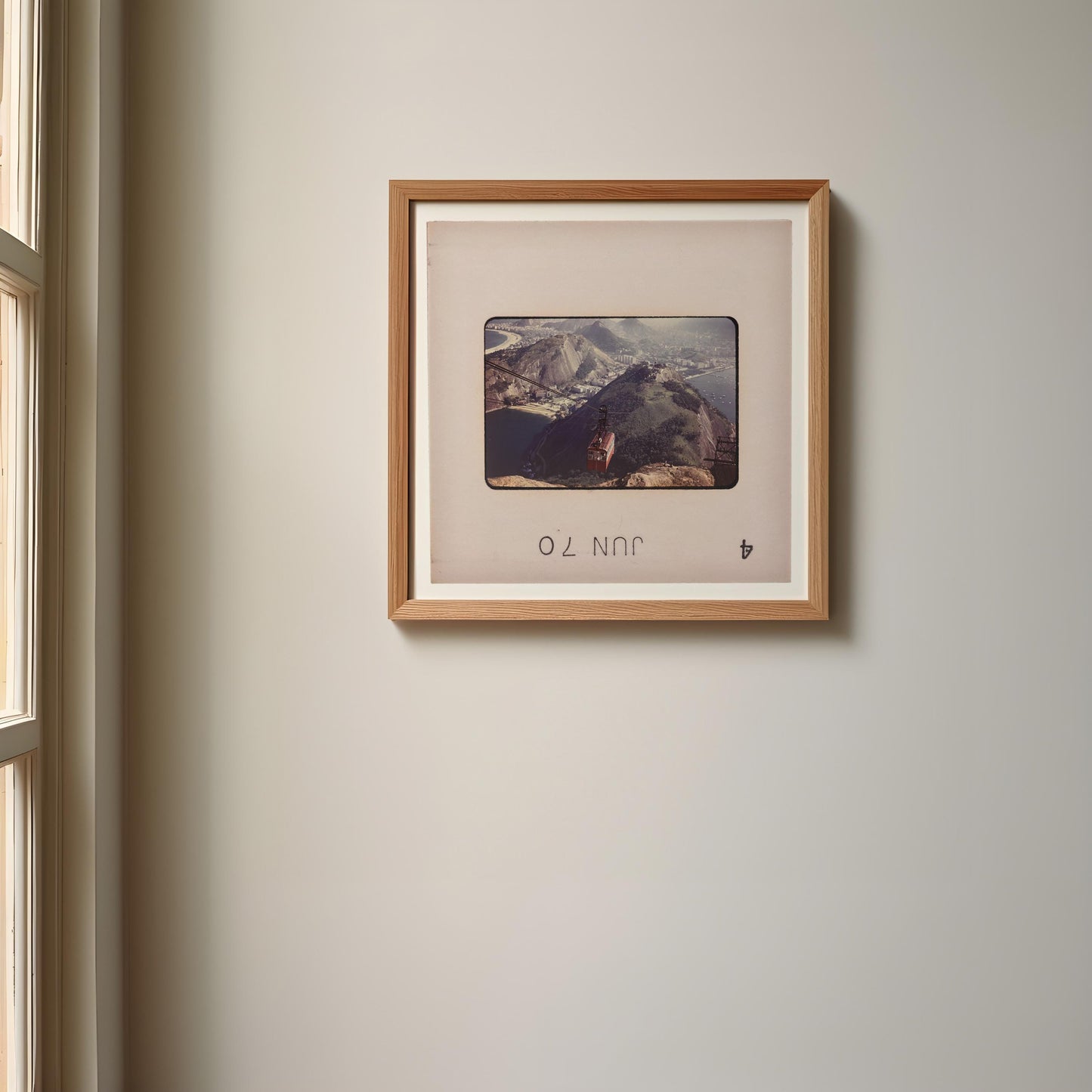 a framed photograph of a mountain landscape hanging on a wall.