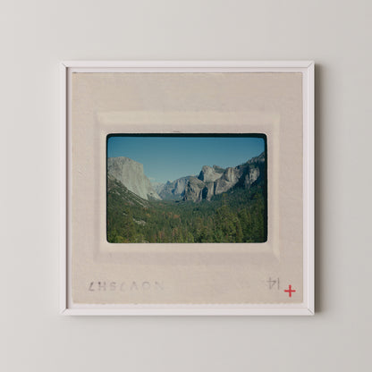 The image is a framed photograph of a scenic mountain landscape, with the mountains visible in the background.