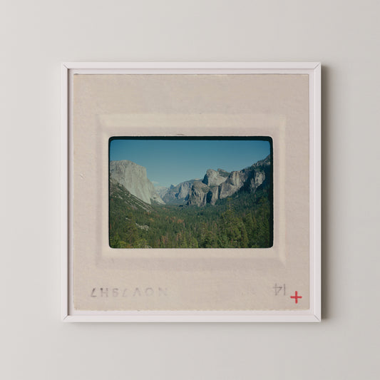 The image is a framed photograph of a scenic mountain landscape, with the mountains visible in the background.