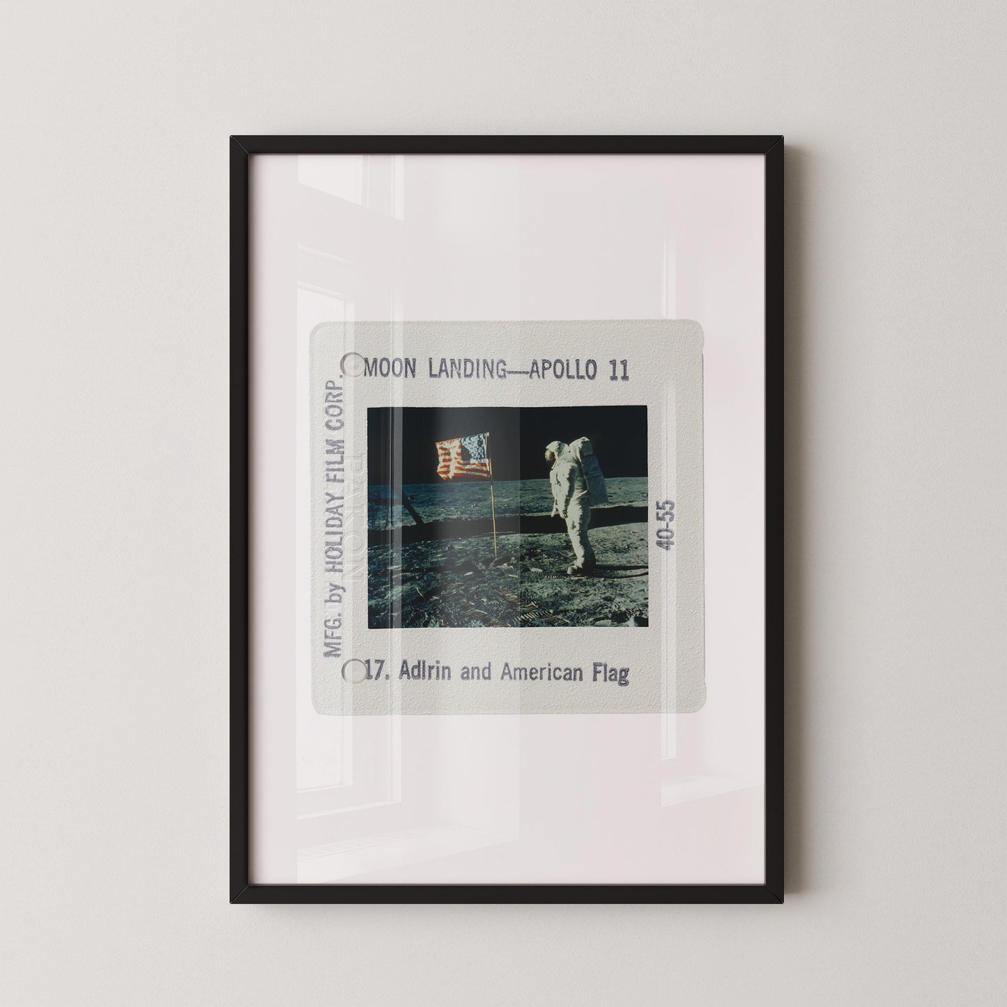 The image is a framed photograph of the Apollo 11 moon landing, featuring the astronaut walking on the lunar surface.