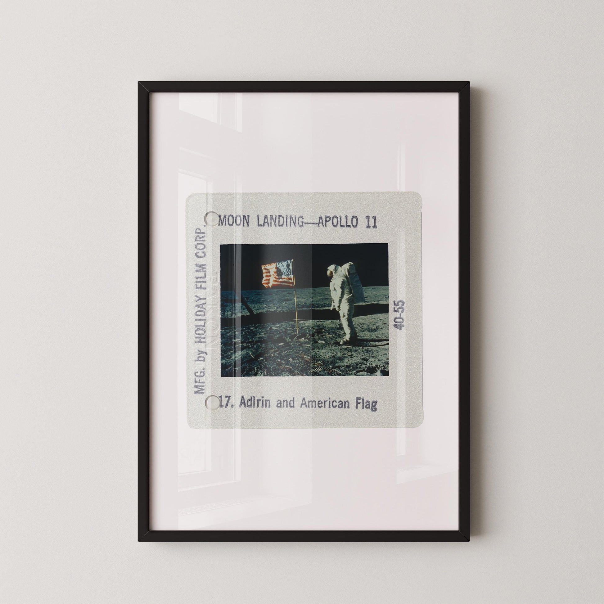 The image is a framed photograph of the Apollo 11 moon landing, featuring the astronaut walking on the lunar surface.