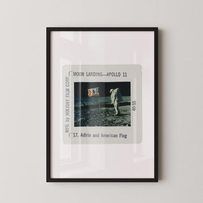 The image is a framed photograph of the Apollo 11 moon landing, featuring the astronaut walking on the lunar surface.