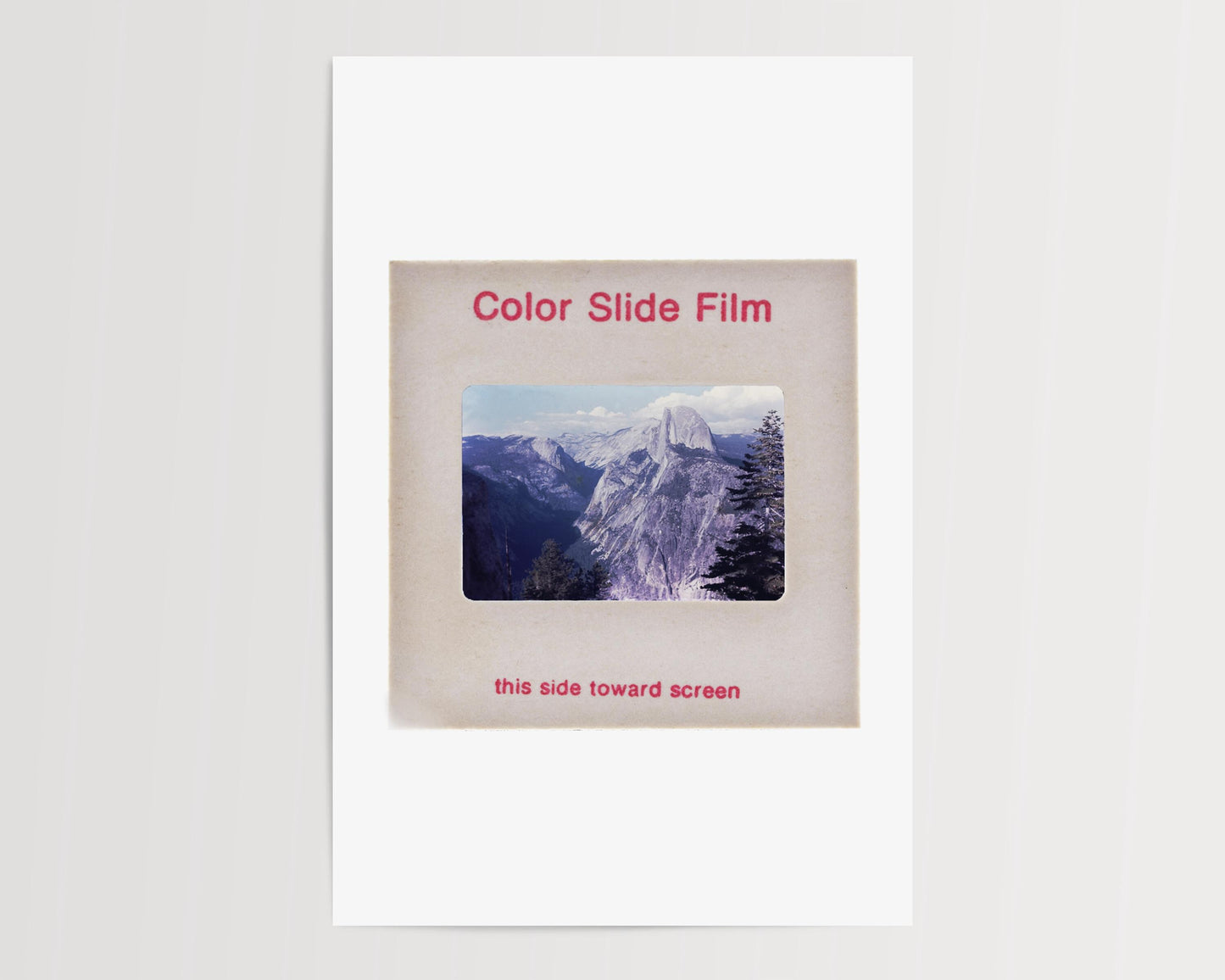 The image is a slide from a color slide film, depicting a mountainous landscape with a clear sky.