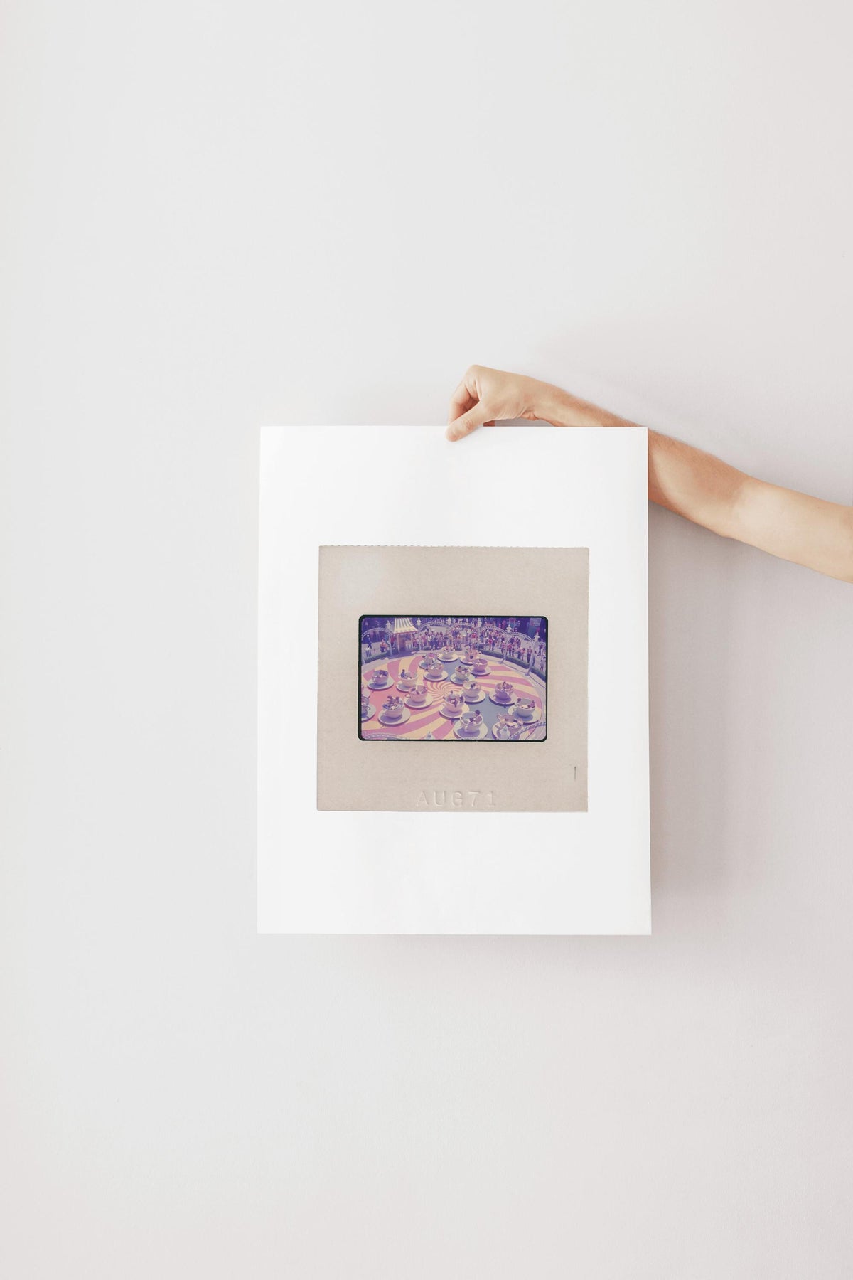 A hand is holding a framed picture of a cityscape, with the word "AUBET" visible on the frame.