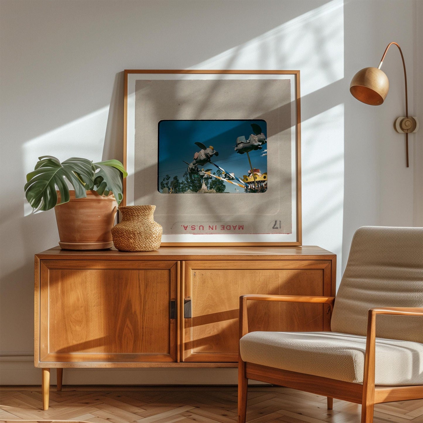 a cozy living room with a wooden cabinet, a framed picture of a tropical scene, a potted plant, and a beige armchair.