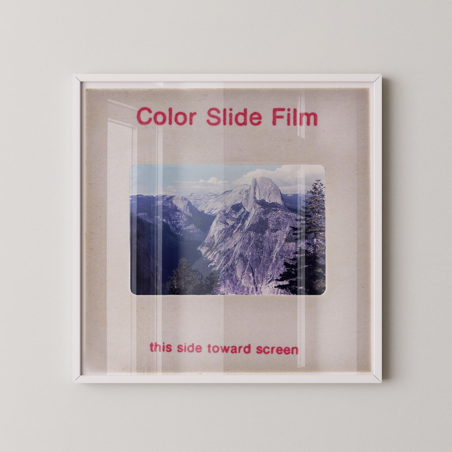 The image is a framed photograph of a mountain landscape, with the text "Color Slide Film" and "this side toward screen" printed on the frame.