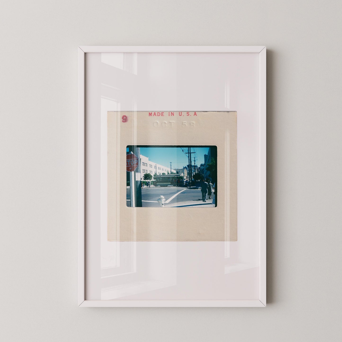Vintage 1958 Kodachrome slide photograph of a San Francisco cable car passing through a sunny city intersection, with pedestrians in period dress, a red stop sign, utility poles, and a bright blue autumn sky. Printed as a giclée fine art print on archival matte paper.