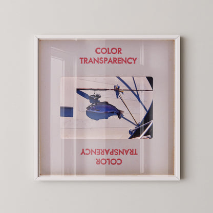 The image is a framed photograph of a blue object, possibly a piece of machinery or equipment, with the text "COLOR TRANSPARENCY" and "COLOR" visible.