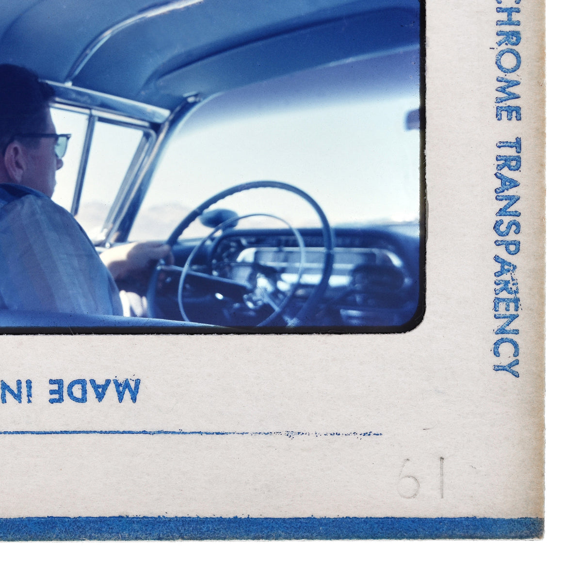 a person sitting in the driver's seat of a car, with the steering wheel visible in the background.