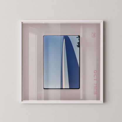 a framed photograph of a blue and white striped structure, possibly a building or monument, displayed on a wall.