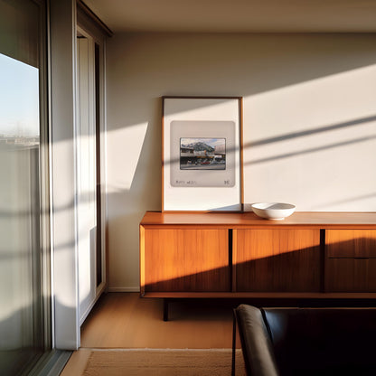 a modern living room with a wooden cabinet, a framed picture on the wall, and a window with white blinds.